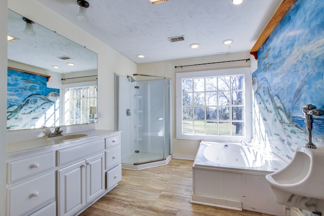 bathroom with vanity, a textured ceiling, plus walk in shower, and wood-type flooring