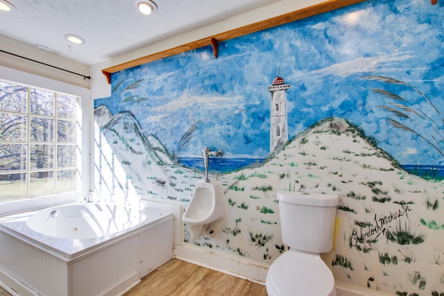 bathroom with a tub to relax in, hardwood / wood-style flooring, and toilet