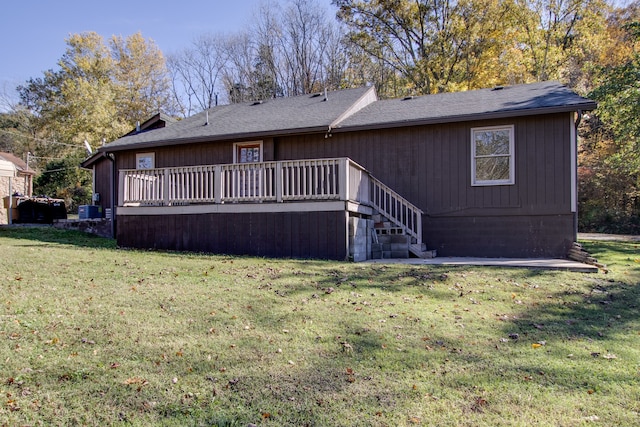 rear view of property featuring a wooden deck, a yard, and central air condition unit