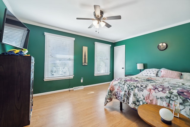 bedroom with crown molding, light wood-type flooring, and ceiling fan