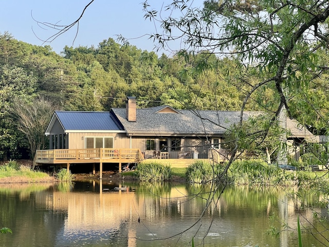 rear view of house with a deck with water view