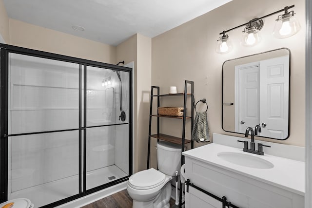 bathroom with toilet, an enclosed shower, vanity, and wood-type flooring