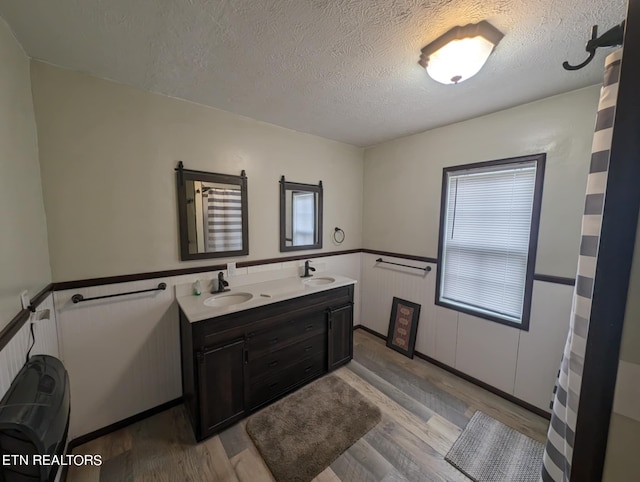 bathroom featuring a textured ceiling, a healthy amount of sunlight, and wood-type flooring