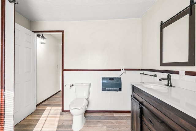 bathroom with vanity, hardwood / wood-style floors, a textured ceiling, and toilet