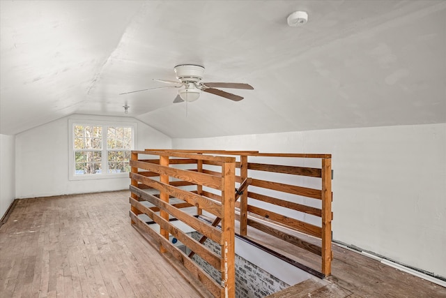 additional living space featuring lofted ceiling, hardwood / wood-style flooring, and ceiling fan