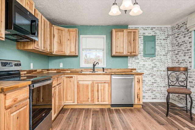 kitchen with wooden counters, sink, hanging light fixtures, and stainless steel appliances