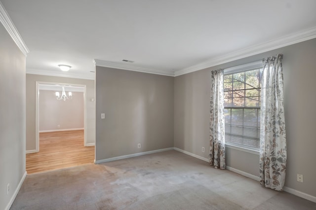 spare room with ornamental molding, a chandelier, and light colored carpet