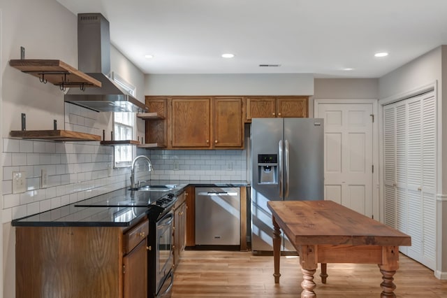 kitchen with decorative backsplash, wall chimney exhaust hood, stainless steel appliances, sink, and light hardwood / wood-style floors