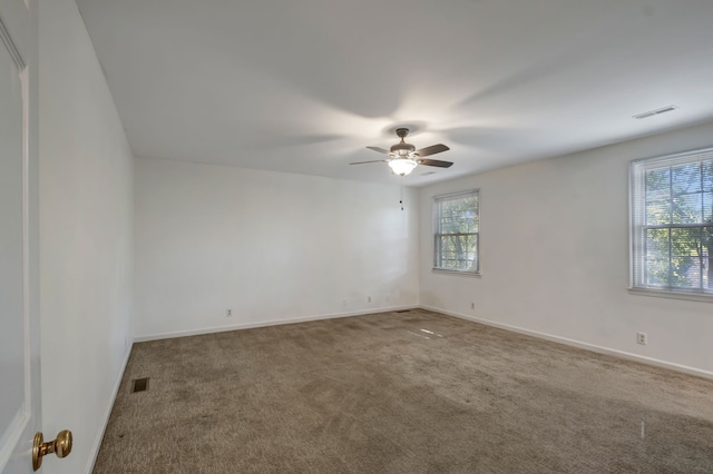 carpeted empty room with plenty of natural light and ceiling fan