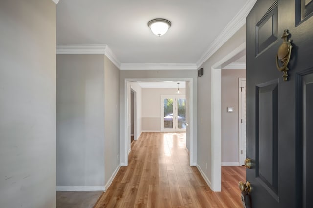 hall with crown molding, light wood-type flooring, and french doors