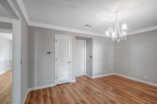 empty room with crown molding and light hardwood / wood-style flooring