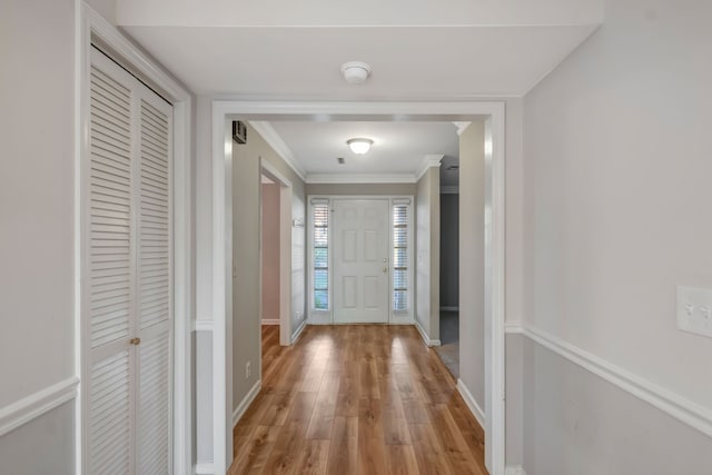 doorway to outside featuring ornamental molding and light hardwood / wood-style flooring