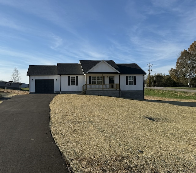 ranch-style home with a porch and a garage