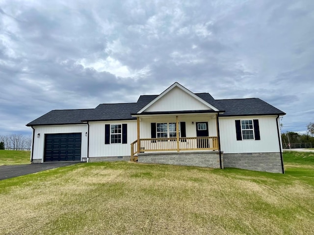 view of front of home featuring covered porch, a garage, and a front yard