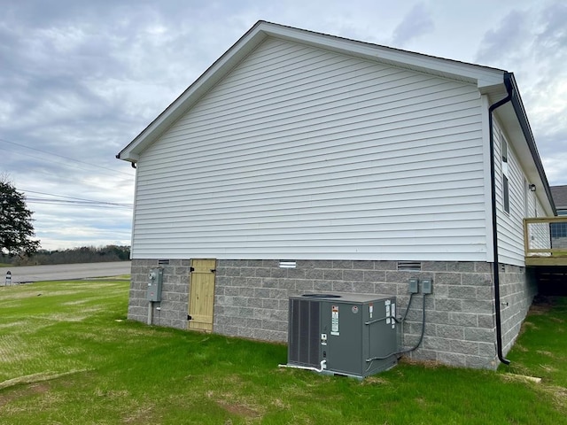 view of side of home featuring a yard and cooling unit