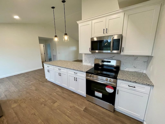 kitchen with white cabinetry, hanging light fixtures, stainless steel appliances, and vaulted ceiling