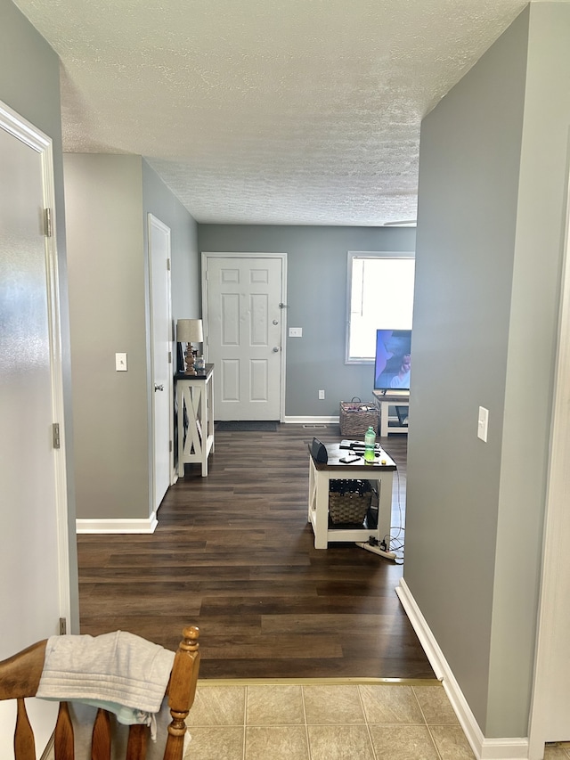 hall with a textured ceiling and hardwood / wood-style flooring