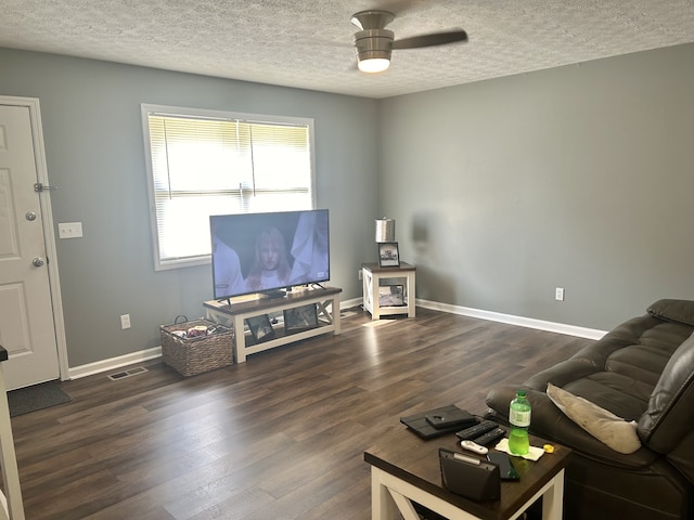 living room with a textured ceiling, ceiling fan, and dark hardwood / wood-style flooring