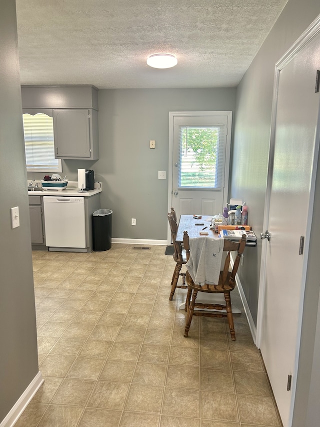 tiled dining room featuring sink and a textured ceiling