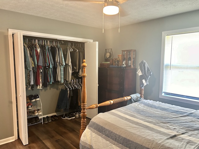 bedroom with a closet, a textured ceiling, ceiling fan, and dark hardwood / wood-style flooring