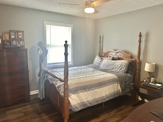 bedroom with a textured ceiling, ceiling fan, and dark hardwood / wood-style flooring