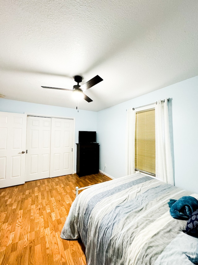 bedroom featuring a closet, ceiling fan, hardwood / wood-style flooring, and a textured ceiling