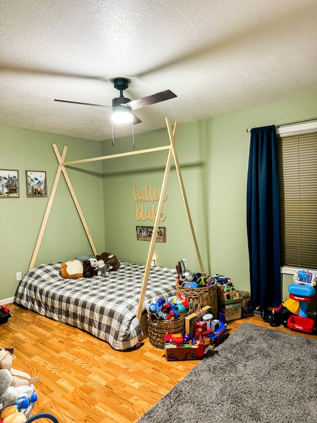 bedroom featuring a textured ceiling, wood-type flooring, and ceiling fan