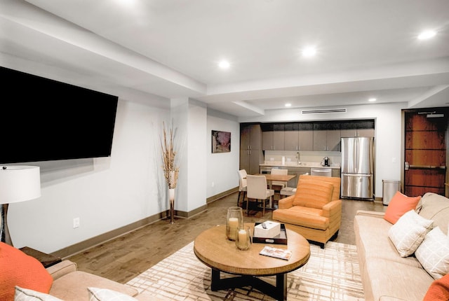 living room featuring sink and light hardwood / wood-style floors