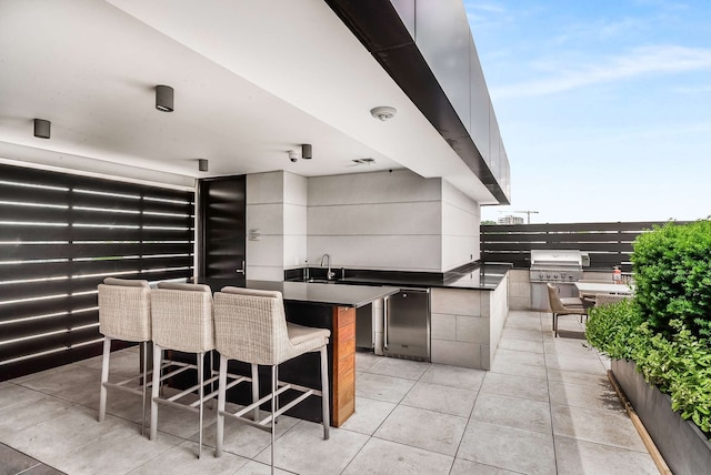 view of patio featuring exterior kitchen, sink, and a grill