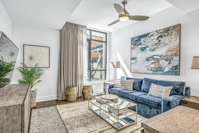 living room with a wealth of natural light, wood-type flooring, and ceiling fan