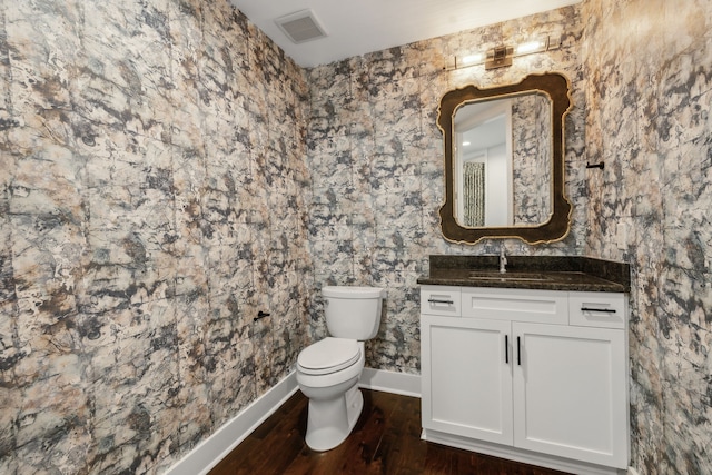 bathroom featuring vanity, wood-type flooring, and toilet