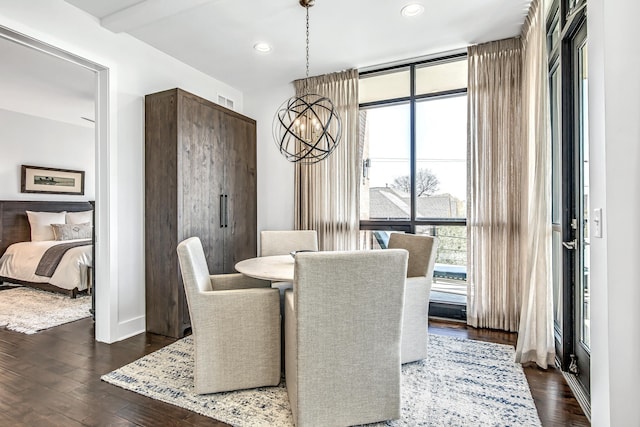 dining room featuring dark wood-type flooring, a notable chandelier, and beamed ceiling