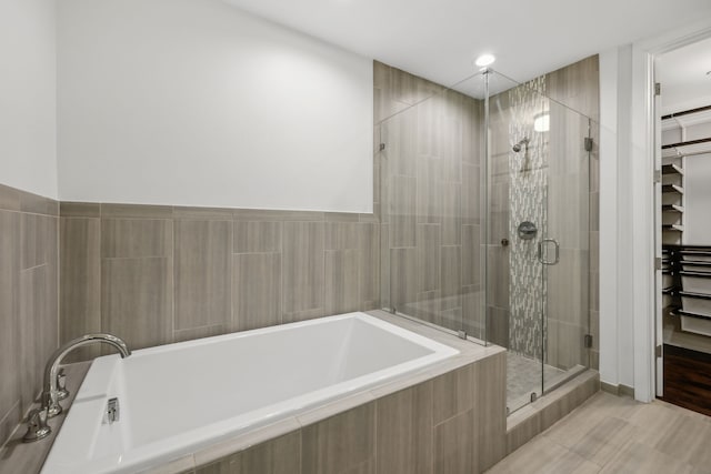 bathroom featuring shower with separate bathtub