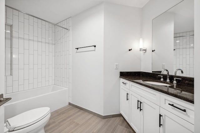 full bathroom with toilet, tiled shower / bath combo, and vanity