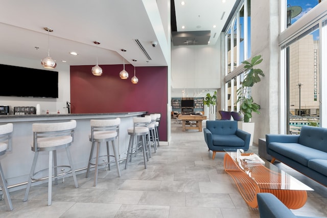 bar with a wealth of natural light and decorative light fixtures