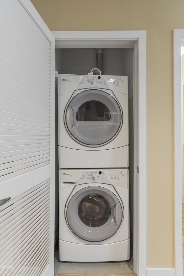 clothes washing area with stacked washer and clothes dryer