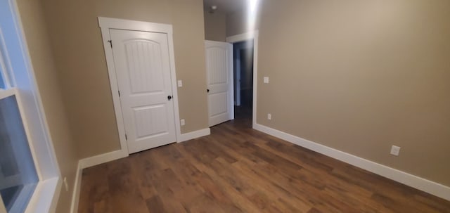 unfurnished bedroom with dark hardwood / wood-style flooring