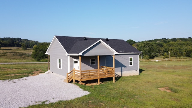 rear view of property featuring a deck and a lawn