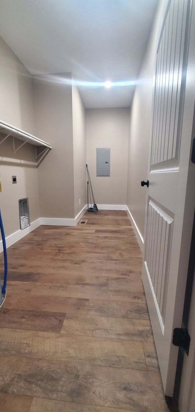 clothes washing area with hardwood / wood-style floors, electric dryer hookup, and electric panel