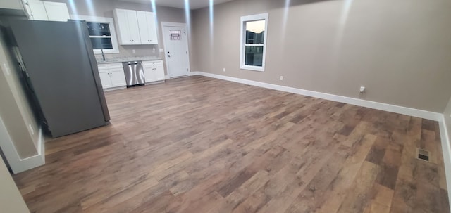 kitchen with white cabinets, stainless steel appliances, and hardwood / wood-style flooring