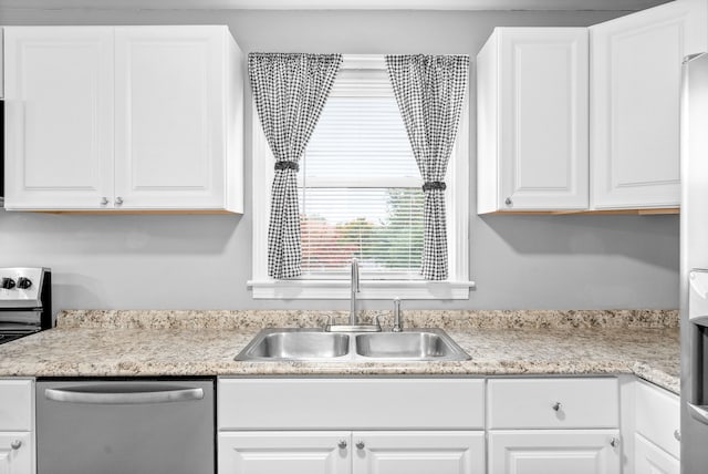 kitchen featuring appliances with stainless steel finishes, white cabinetry, and sink