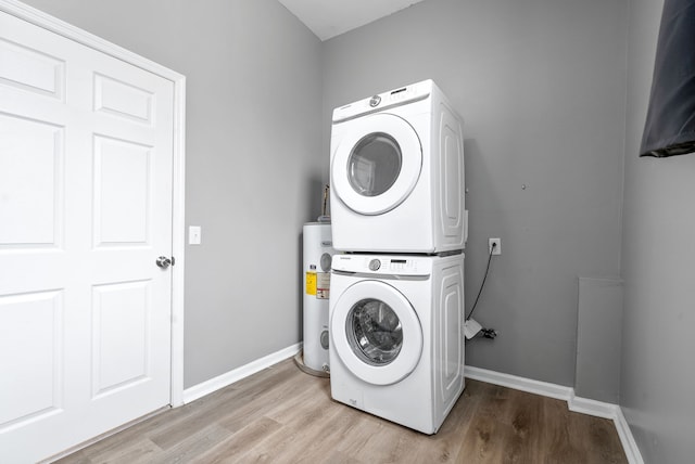 laundry room with stacked washing maching and dryer, water heater, and light wood-type flooring