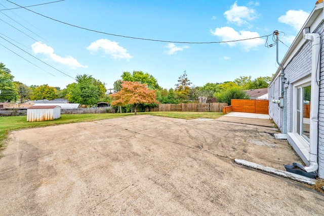 view of yard featuring a patio and a storage shed