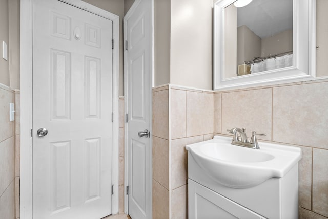 bathroom featuring vanity, tile walls, and curtained shower