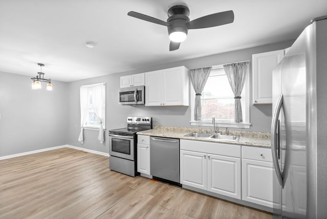 kitchen with light hardwood / wood-style flooring, stainless steel appliances, sink, and a wealth of natural light