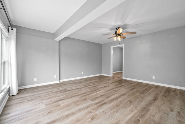 spare room featuring light hardwood / wood-style floors, beam ceiling, and ceiling fan