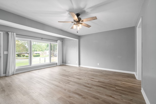 empty room with hardwood / wood-style flooring and ceiling fan