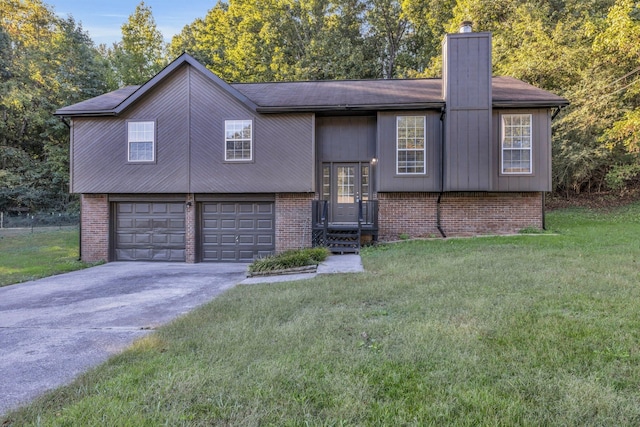 bi-level home featuring a garage and a front lawn