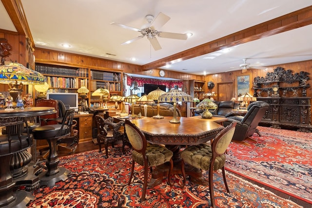 dining room with ceiling fan and wood walls