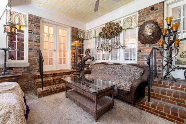 interior space featuring brick wall, french doors, carpet flooring, and wooden ceiling